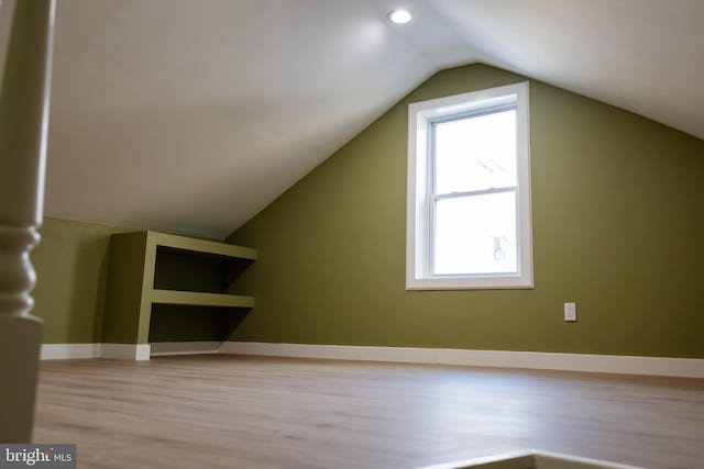 bonus room featuring vaulted ceiling and light hardwood / wood-style flooring