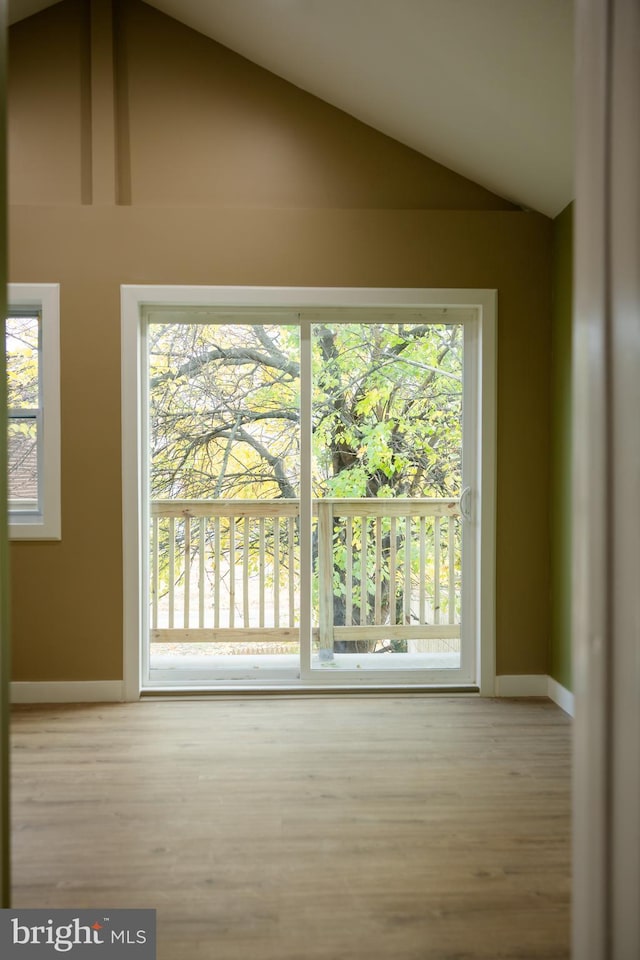 unfurnished room with hardwood / wood-style floors and high vaulted ceiling