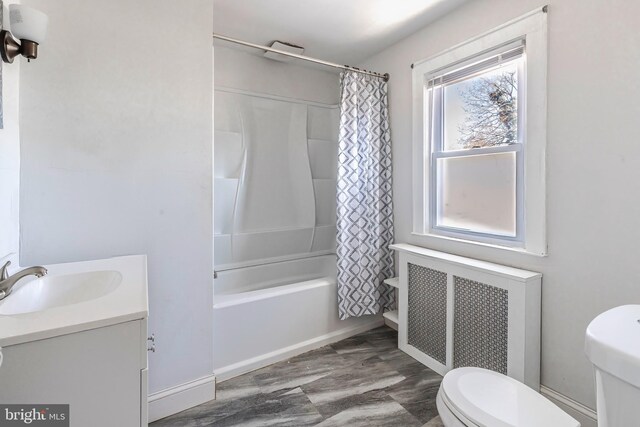 full bathroom with vanity, radiator heating unit, shower / bath combo with shower curtain, and toilet