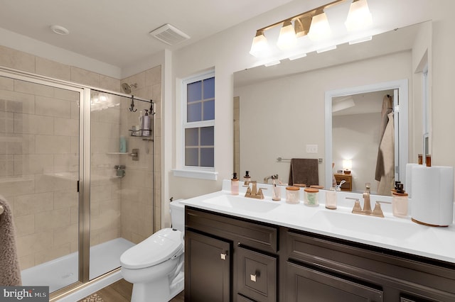 bathroom with wood-type flooring, vanity, toilet, and walk in shower