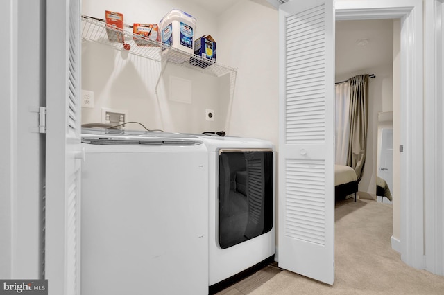 laundry room featuring washing machine and clothes dryer and light carpet