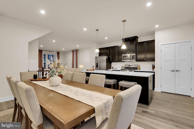 dining space with light hardwood / wood-style flooring and sink