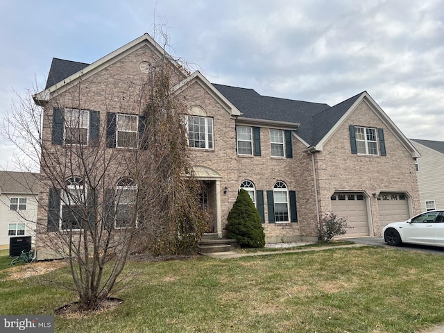 view of front of house featuring cooling unit, a front yard, and a garage