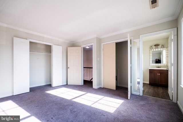 unfurnished bedroom with connected bathroom, ornamental molding, and dark colored carpet