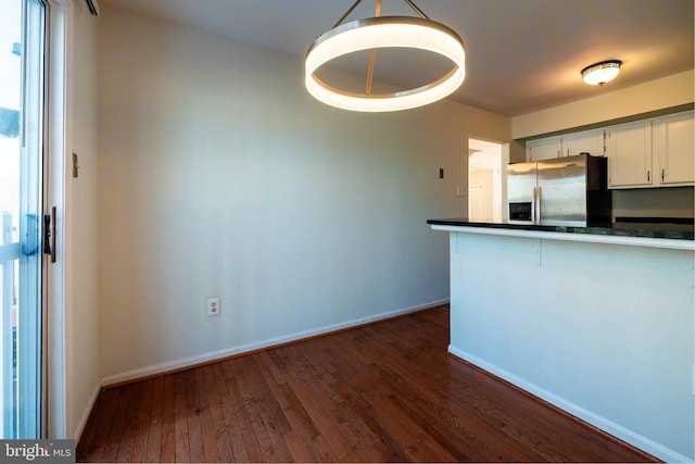 kitchen featuring dark hardwood / wood-style flooring, decorative light fixtures, white cabinets, and stainless steel refrigerator with ice dispenser