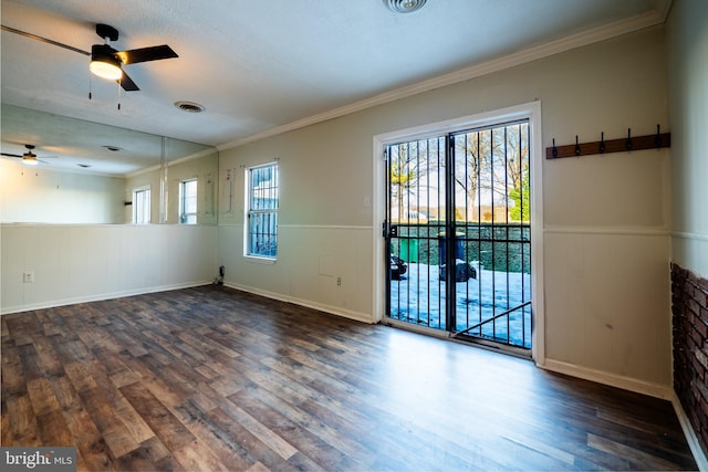 empty room with ceiling fan, ornamental molding, dark hardwood / wood-style floors, and a healthy amount of sunlight