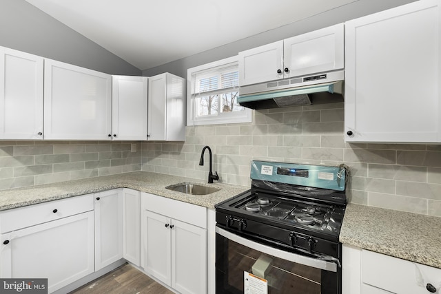 kitchen featuring gas stove, sink, backsplash, lofted ceiling, and white cabinets