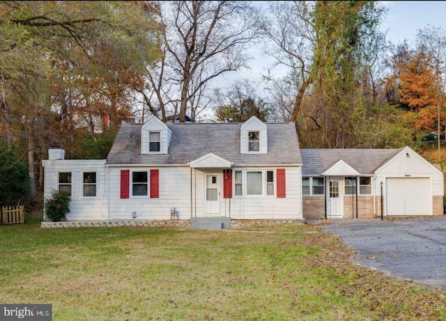 cape cod-style house featuring a garage and a front lawn