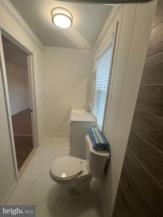 bathroom with ornamental molding, vanity, and toilet