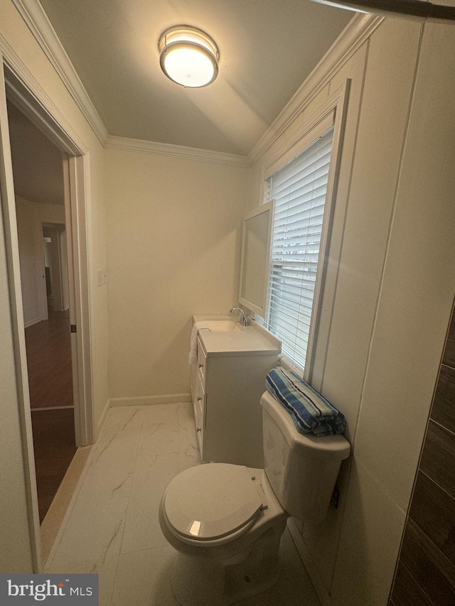 bathroom with vanity, crown molding, and toilet