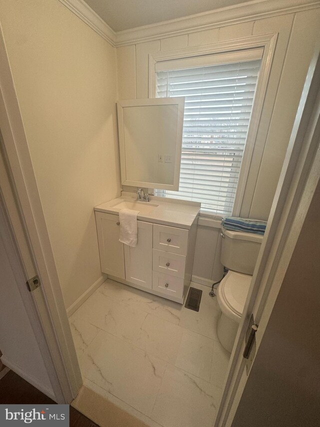 bathroom featuring crown molding, vanity, and toilet