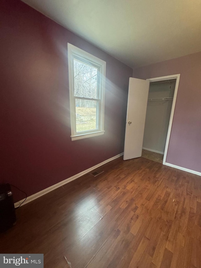 unfurnished bedroom featuring hardwood / wood-style floors and a closet