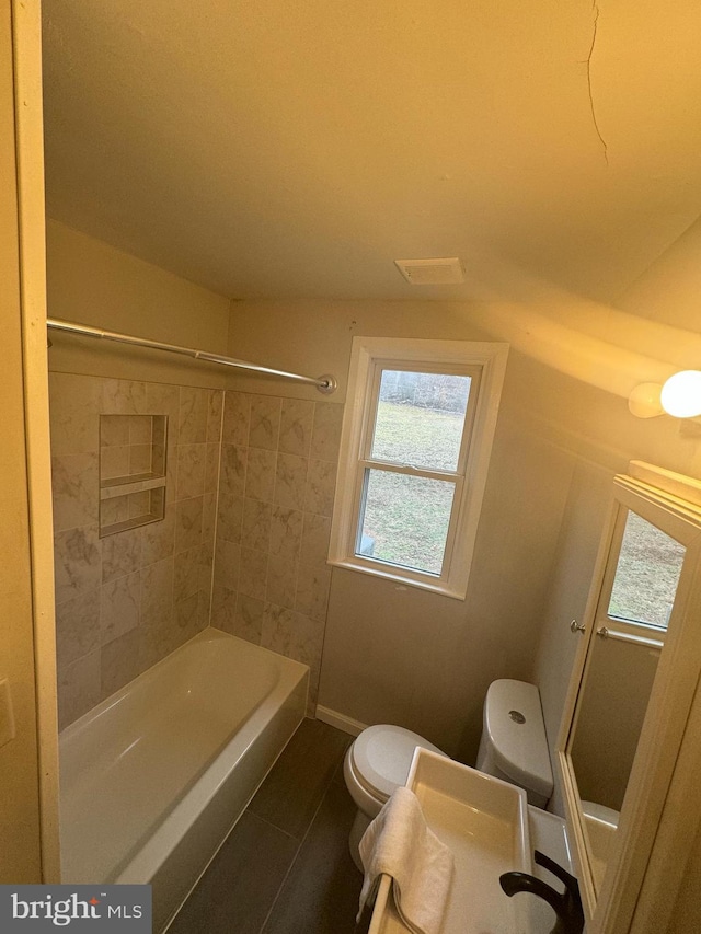 bathroom with tiled shower / bath and toilet