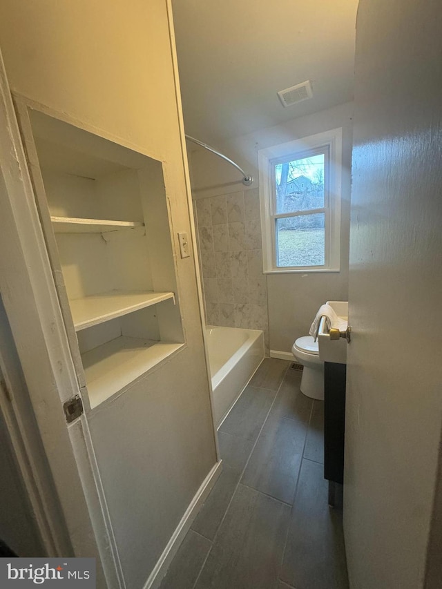 bathroom featuring tiled shower / bath and toilet