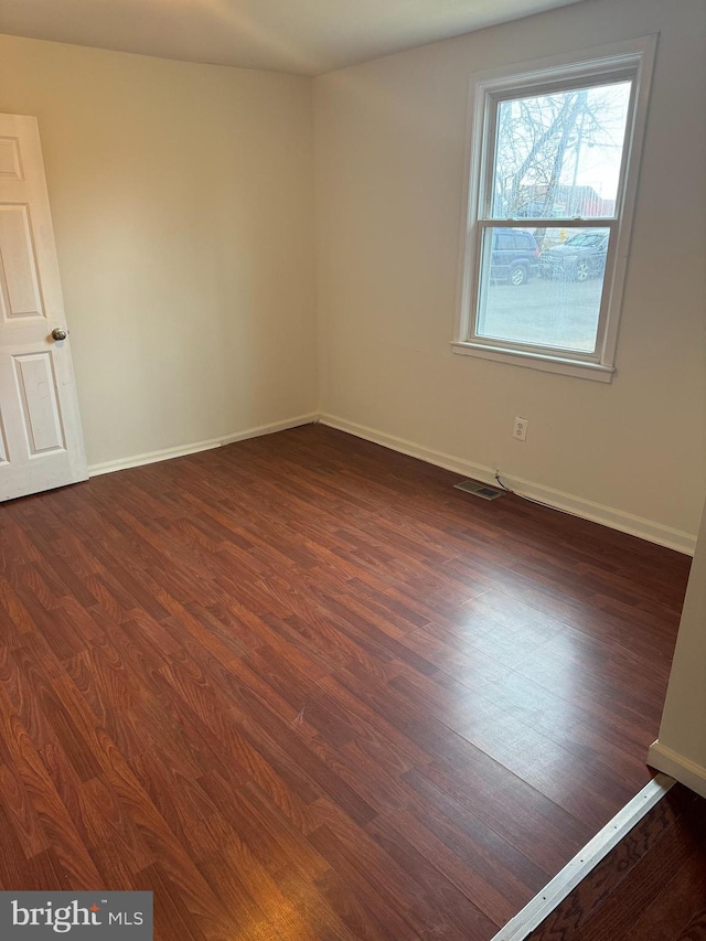 unfurnished room featuring dark wood-type flooring