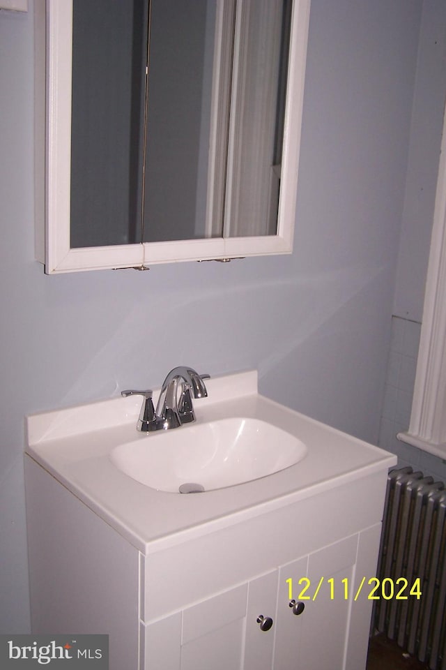 bathroom featuring radiator heating unit and vanity