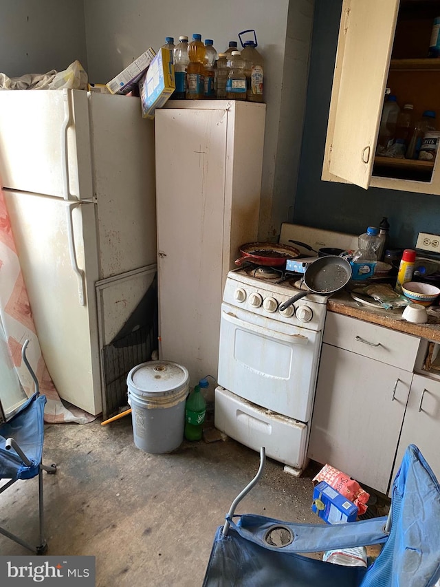 kitchen with white appliances and concrete floors