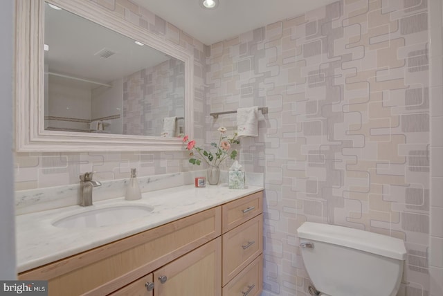 bathroom featuring backsplash, vanity, tile walls, and toilet