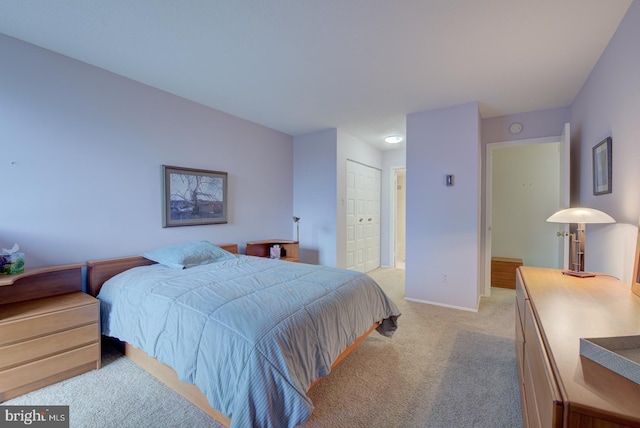 carpeted bedroom with ensuite bathroom and a closet