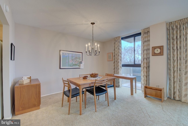 carpeted dining room featuring a chandelier