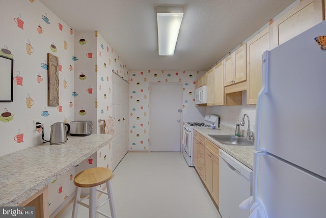 kitchen featuring white appliances, light colored carpet, sink, light brown cabinets, and a breakfast bar area