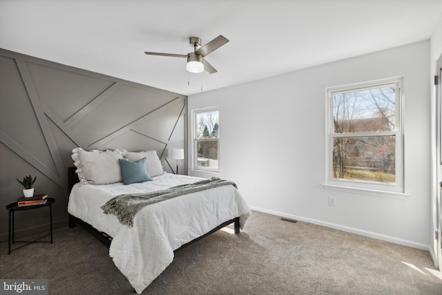 carpeted bedroom with multiple windows and ceiling fan