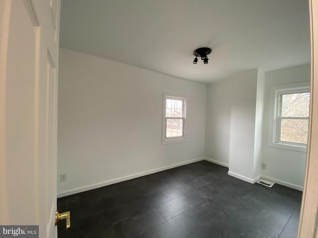 unfurnished room featuring plenty of natural light