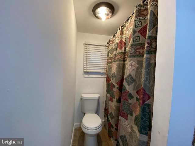 bathroom with tile patterned flooring, a shower with curtain, and toilet