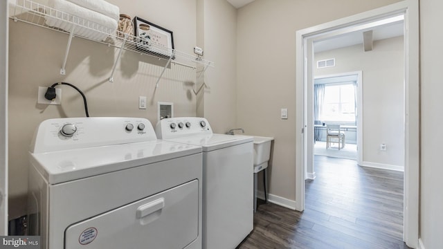 laundry room with washing machine and dryer and dark wood-type flooring