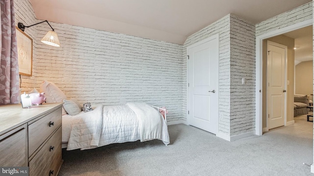 carpeted bedroom with brick wall