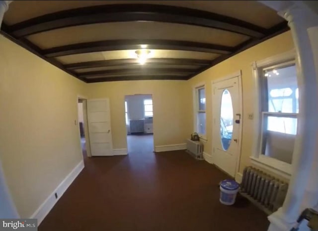 foyer entrance featuring radiator and beamed ceiling