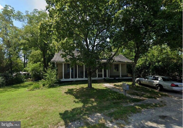 view of front of home featuring a sunroom and a front lawn