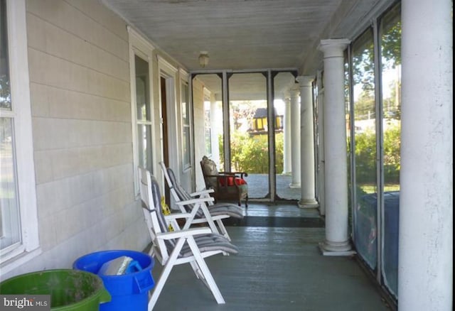 unfurnished sunroom featuring decorative columns and a wealth of natural light