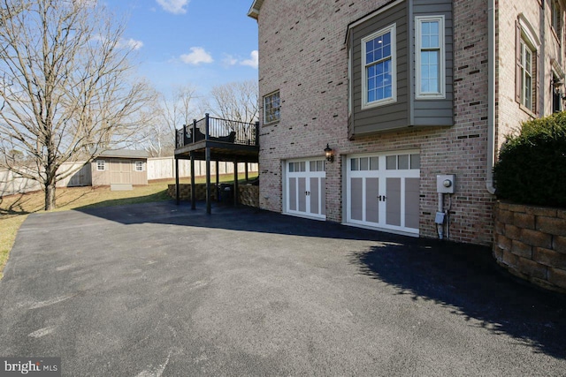 view of side of property featuring a garage and a wooden deck