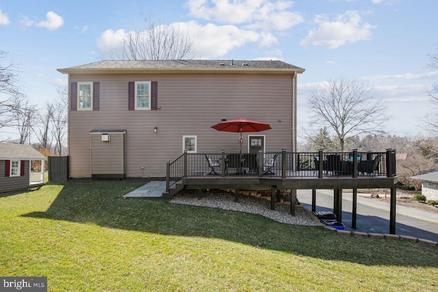 back of property with a wooden deck and a lawn