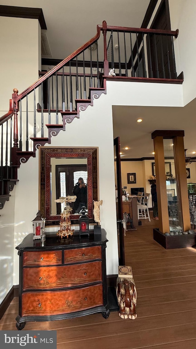 stairs with a towering ceiling and hardwood / wood-style floors