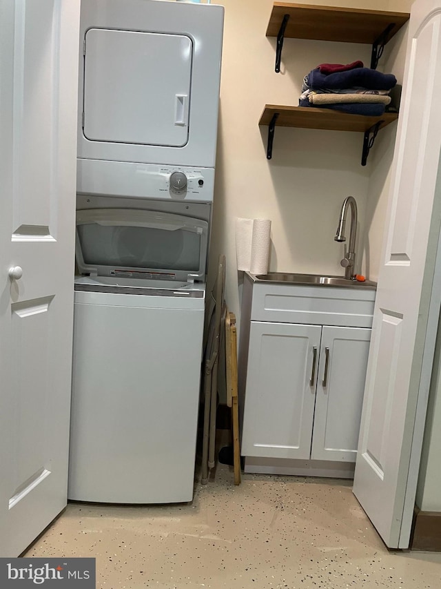 washroom featuring stacked washer and clothes dryer and sink