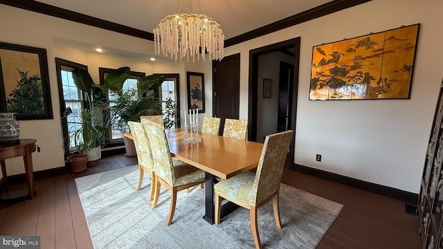 dining area featuring dark wood-type flooring, crown molding, and a notable chandelier