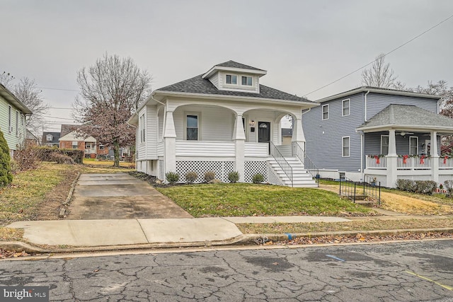 bungalow with covered porch and a front lawn