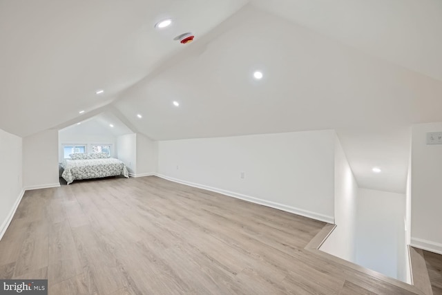 unfurnished bedroom with light hardwood / wood-style floors and lofted ceiling