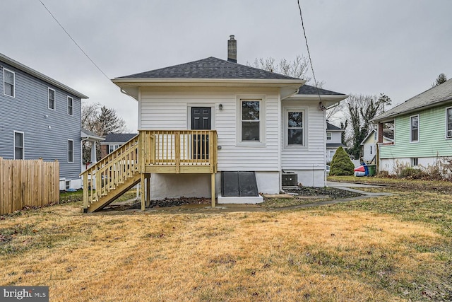 rear view of property featuring cooling unit and a yard