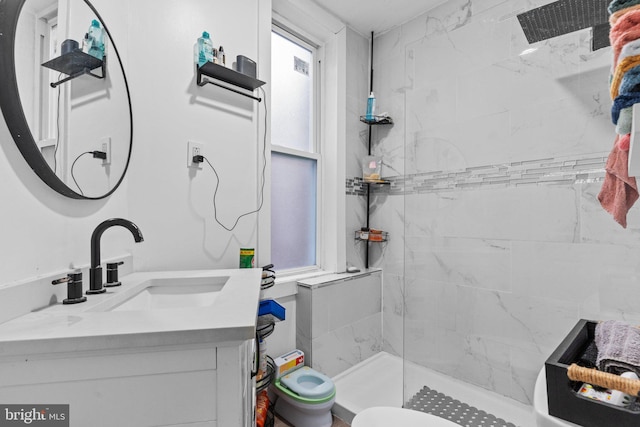 bathroom featuring vanity, toilet, and a shower with door