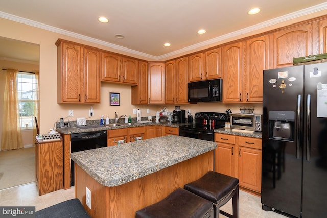 kitchen with light tile patterned flooring, black appliances, crown molding, a kitchen island, and a breakfast bar area