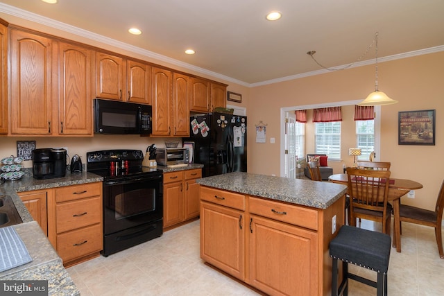 kitchen featuring pendant lighting, a center island, black appliances, and ornamental molding