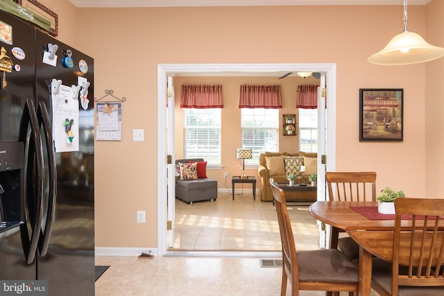 dining room with light tile patterned floors and crown molding