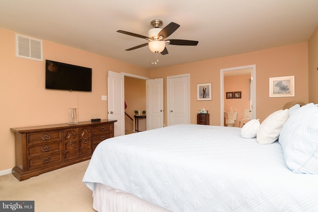 carpeted bedroom featuring ensuite bath and ceiling fan