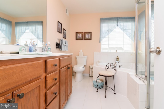 bathroom with vanity, tiled bath, toilet, and plenty of natural light