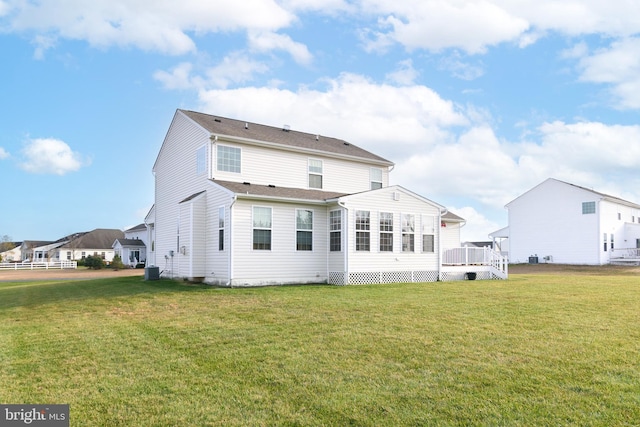 rear view of house with a lawn, a wooden deck, and cooling unit