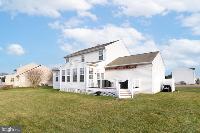 rear view of property featuring a deck and a lawn