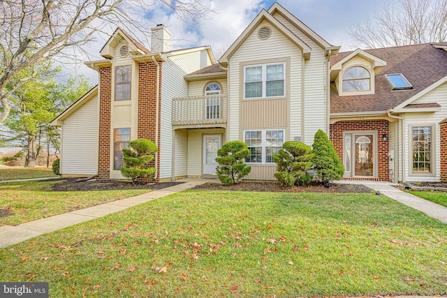 townhome / multi-family property with a front yard and a balcony